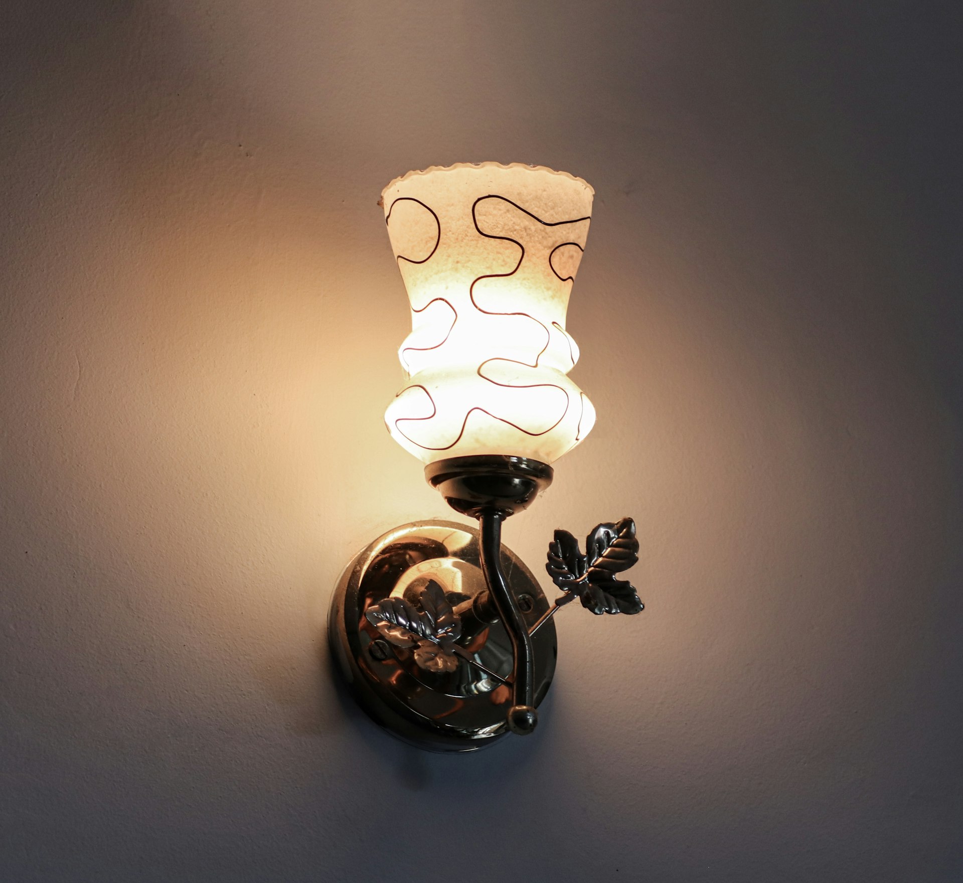 A wall light with a glass shade on it